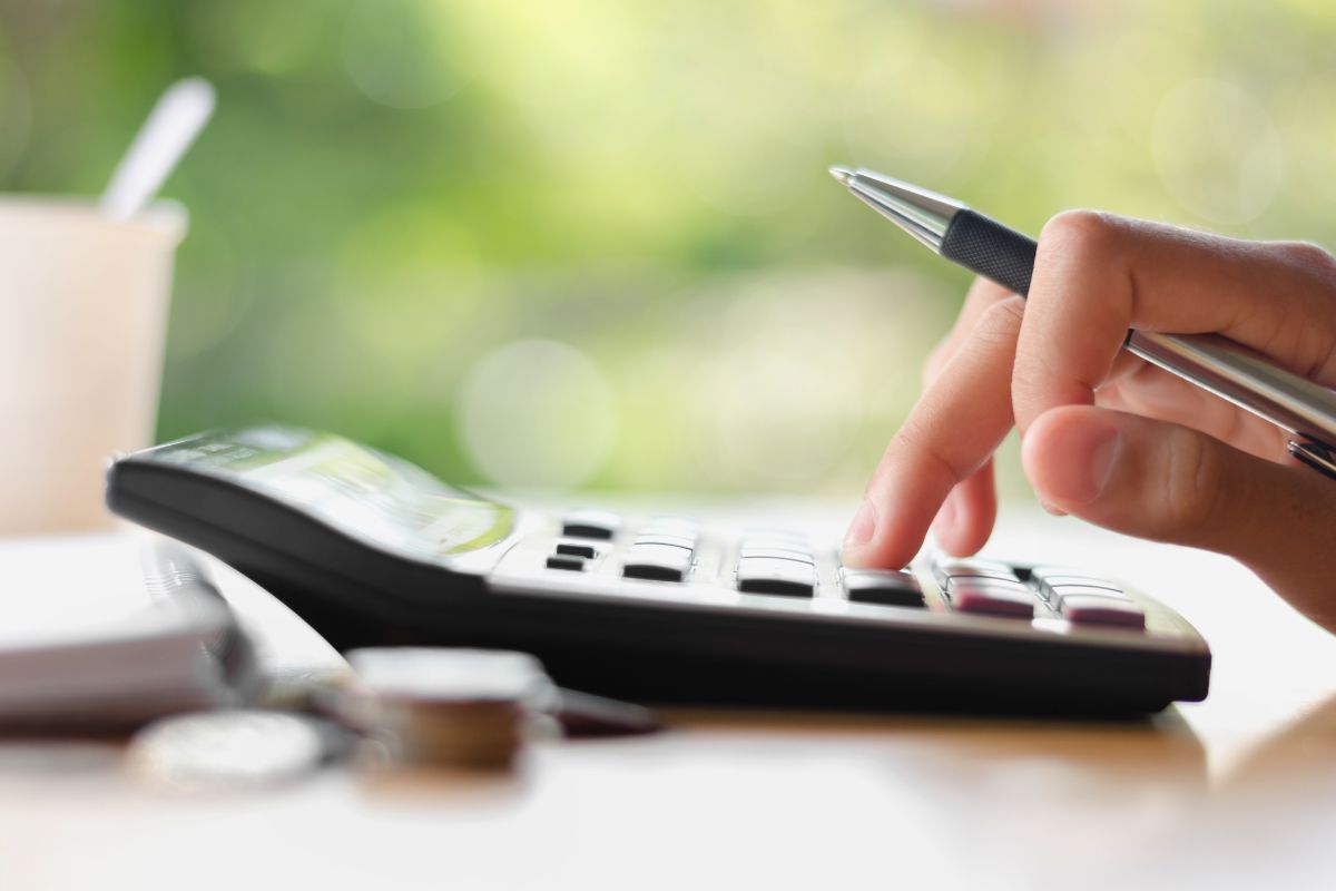 SureBooks- accounting services for small bsuiness South Africa- hand-holding-pen-and-pressing-calculator-min