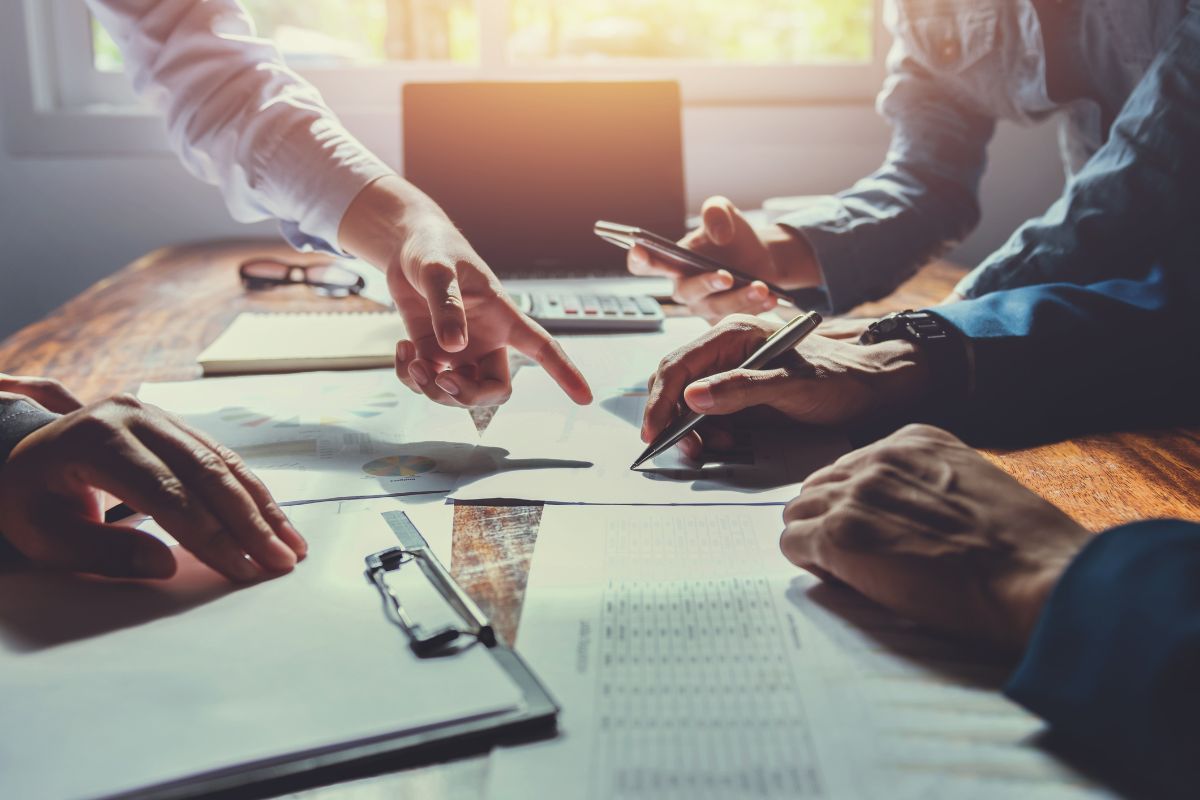 SureBooks- accounting services small business sobusiness-accounting-team-meeting-in-room-office-using-pen-pointing-at-paperwork-finance-min