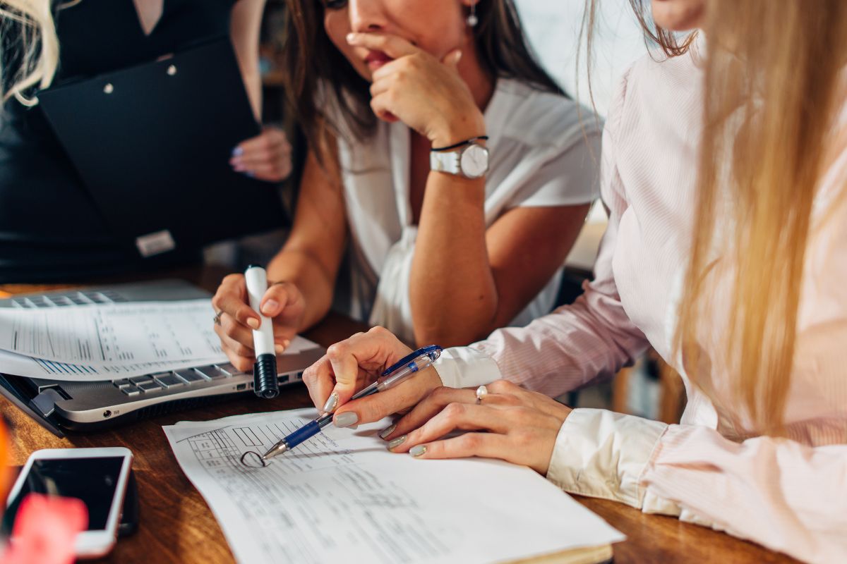 accounting-for-small-business-south-africa-close-up-view-of-young-women-working-on-accounting-paperwork-checking-and-pointing-at-documents-sitting-at-desk