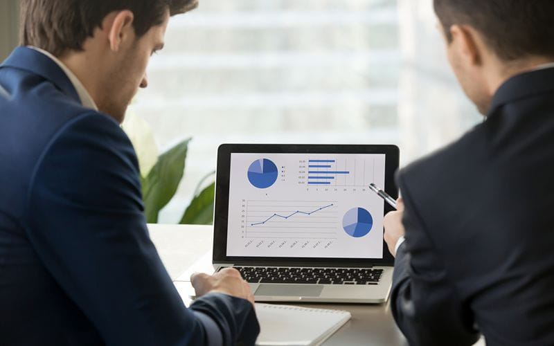 accounting services Cape Town -two-businessmen-analyzing-stats-on-laptop-accounting-software (1)